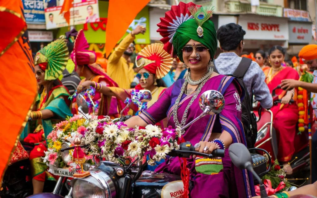 Gudhi Padwa procession — people in traditional Maharashtrian outfits in afternoon sun. Candid, real, warm.